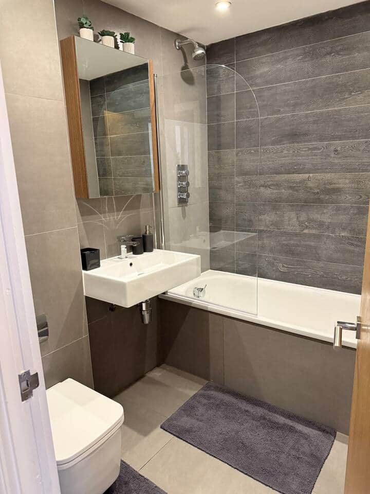 Modern full bathroom with bathtub, shower, toilet and fresh towels. Clean stylish space with toiletries provided, ideal for short breaks or longer stays in Battersea London. Modern full bathroom with bathtub, shower, toilet and fresh towels. Clean stylish space with toiletries provided, ideal for short breaks or longer stays in Battersea London.