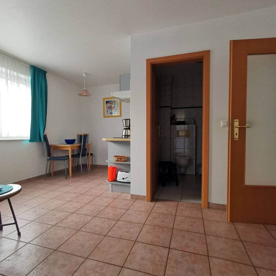 In der offenen Küche gibt es eine Essecke mit ausklappbarem Tisch und 4 Stühlen.