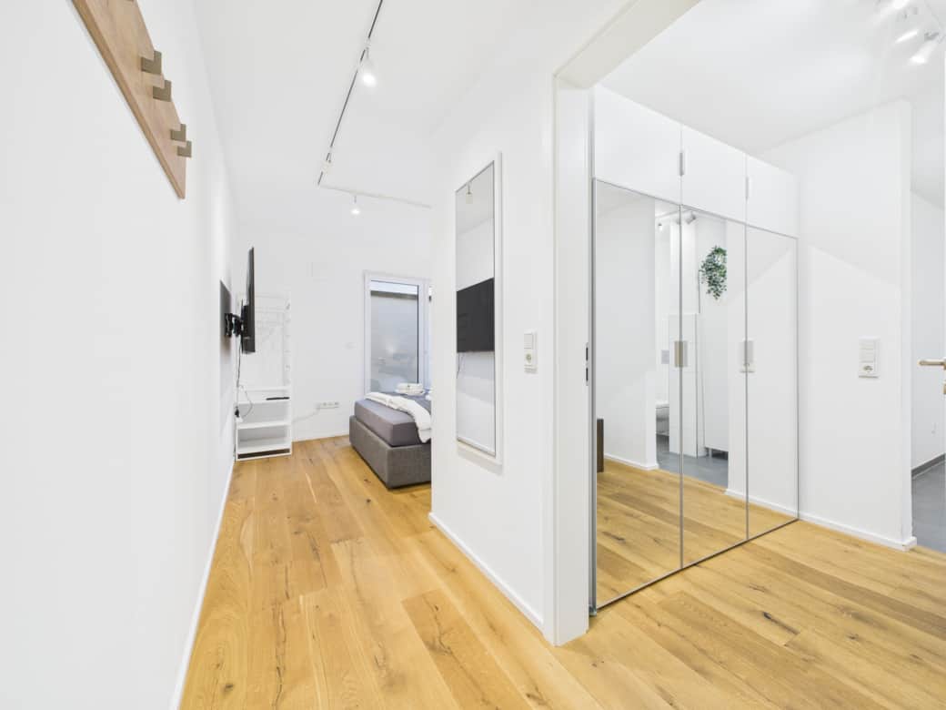 Großzügiger Schlafbereich mit moderner klarer Raumaufteilung und integrierter Ankleide.