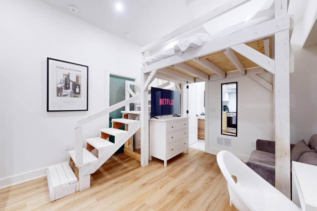 Living room with a platform bed above it