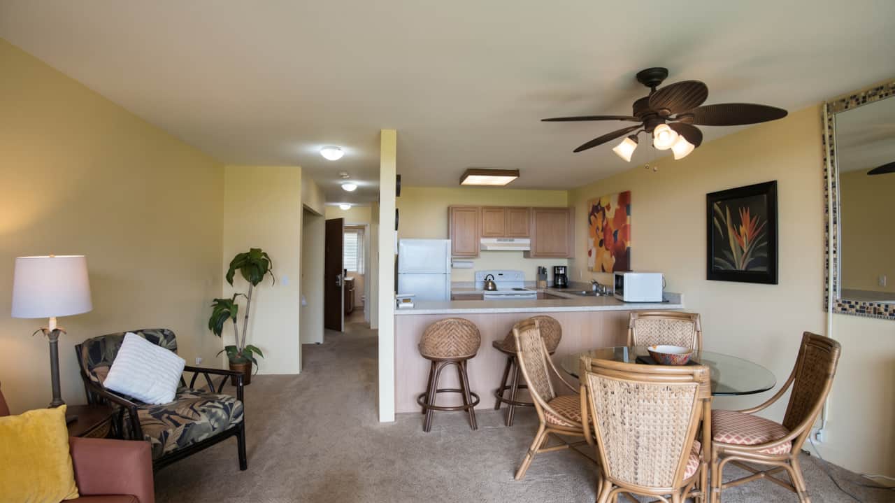 Open-concept living and dining area with breakfast bar seating and a full kitchen.