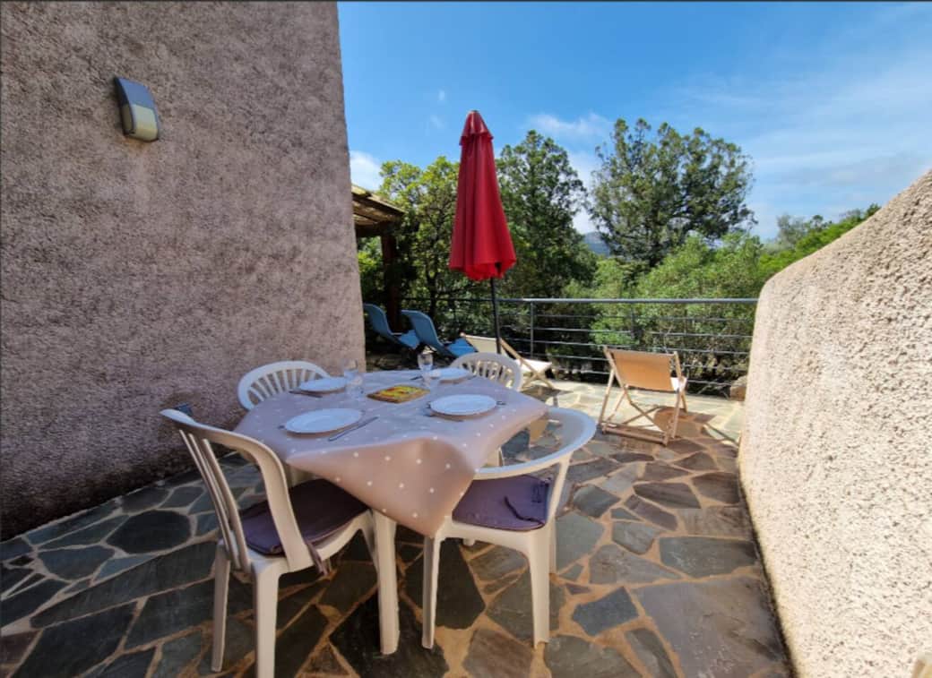 Terrasse ensoleillée avec coin repas et vue sur les montagnes environnantes 