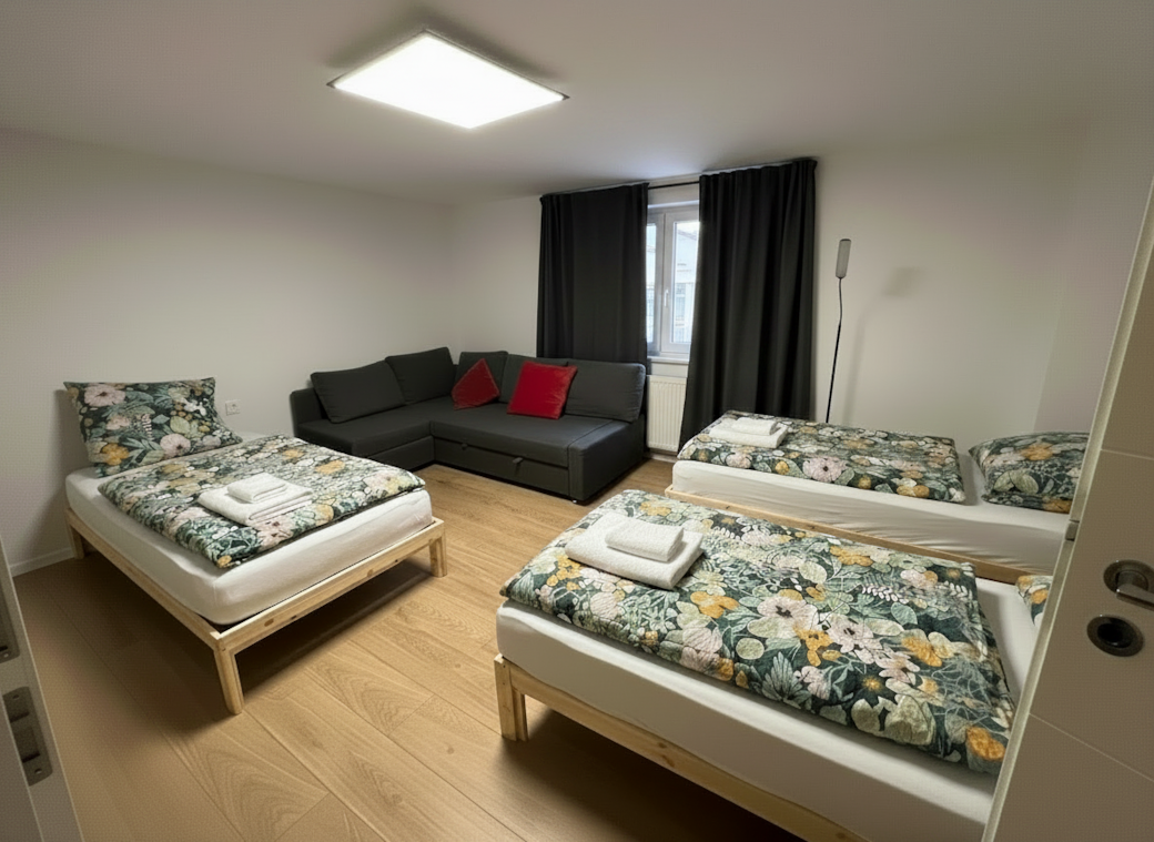 Schlafzimmer mit drei Einzelbetten und Couch Schlafzimmer mit drei Einzelbetten und Couch
