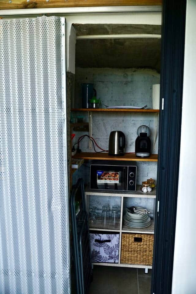 Rangements et équipements électroménager (Réfrigérateur avec compartiment congélateur, micro-ondes, bouilloire, machine à café Dolce Juste).