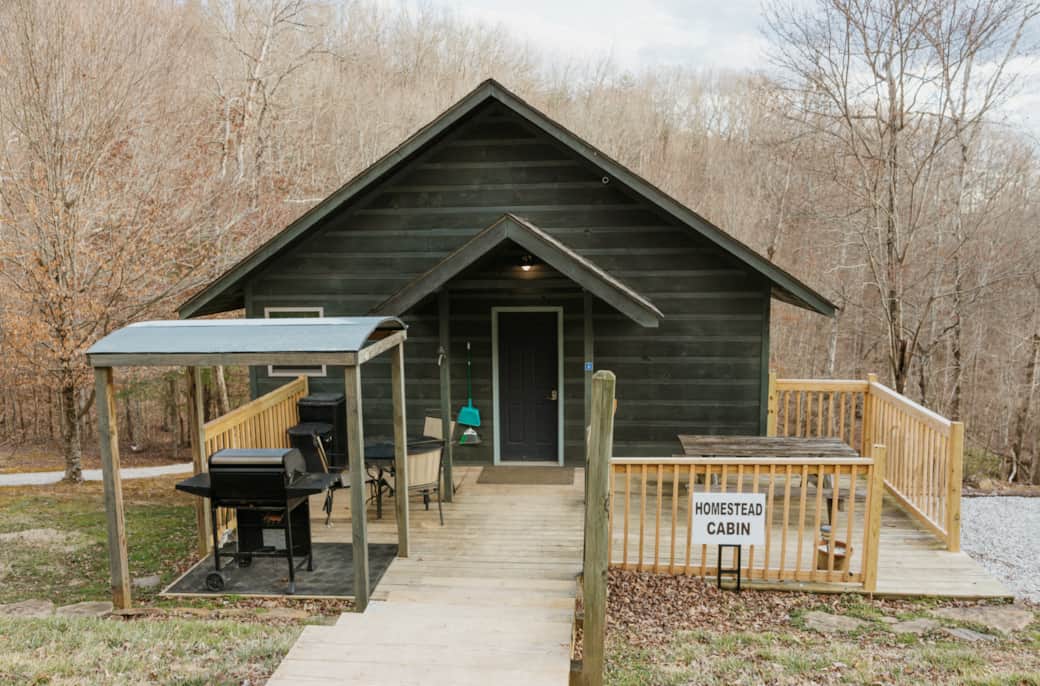 Back view of homestead with large porch, grill, and firepit