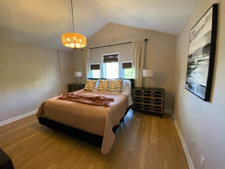 Spacious and inviting bedroom with vaulted ceilings and warm natural light.