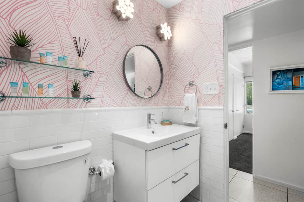 Banana-leaf wallpaper, retro vanity, vintage vibe.