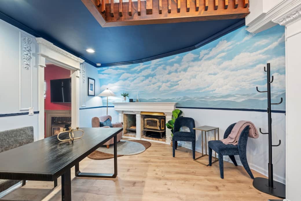 Sky mural dining area with fireplace and cozy seating.