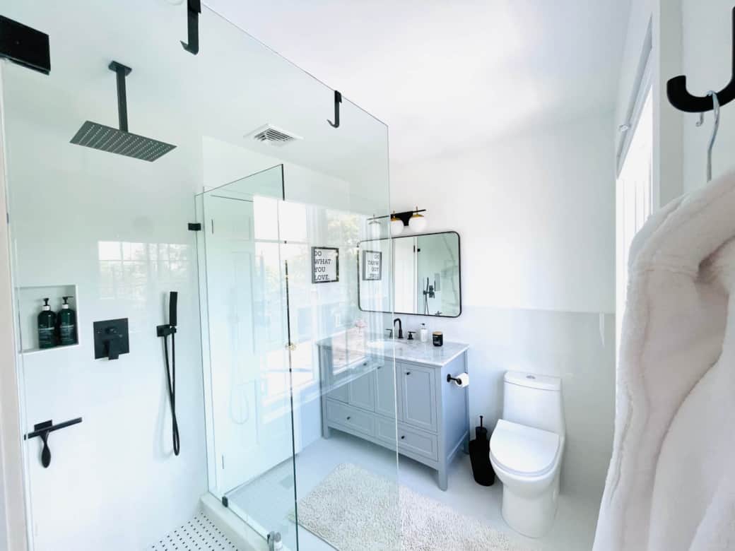 The Black & White bath is newly renovated with glass enclosed rain shower