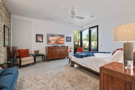 Primary bedroom with king bed and full sized futon and backyard views