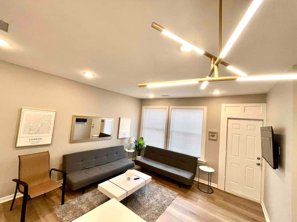 2 futon sofa beds and 50 inch tv connected to kitchen.