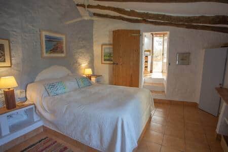 Double bed room with kingsize bed, wardrobe and ceiling fan.
