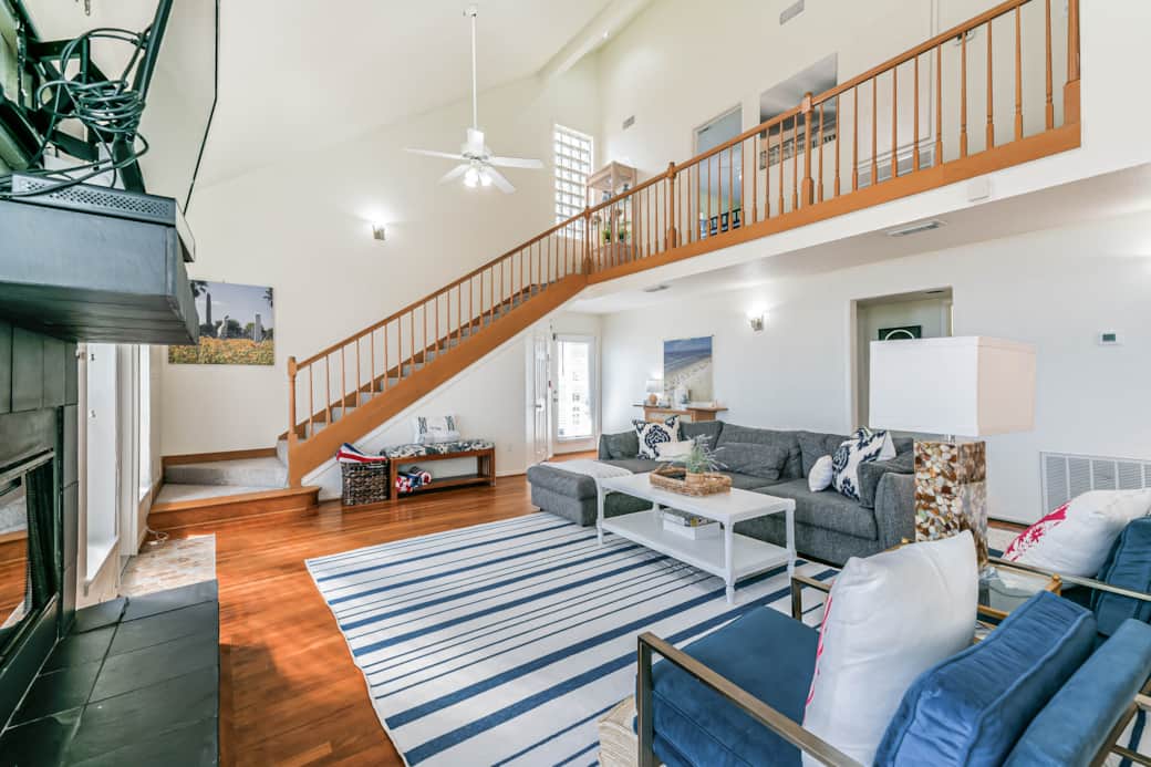 The living room is right off the kitchen/dining area decorated in cool blues and beachy vibes. The living room is right off the kitchen/dining area decorated in cool blues and beachy vibes.