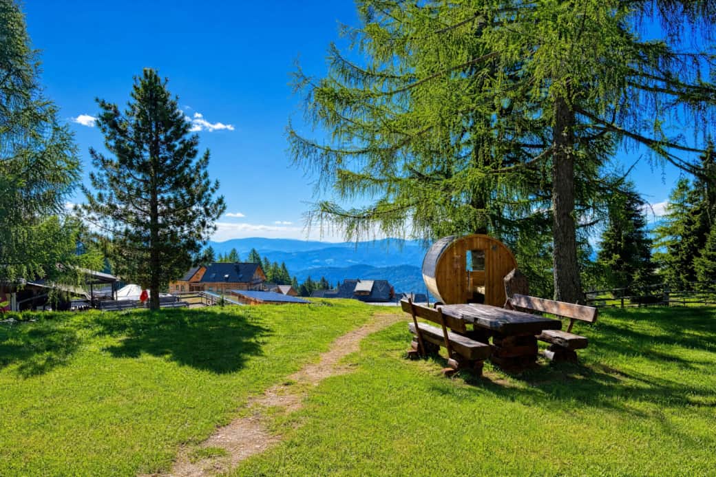 Gemütlicher Ruheplatz mit Panoramabank, Sauna im Hintergrund und freiem Bergblick Gemütlicher Ruheplatz mit Panoramabank, Sauna im Hintergrund und freiem Bergblick