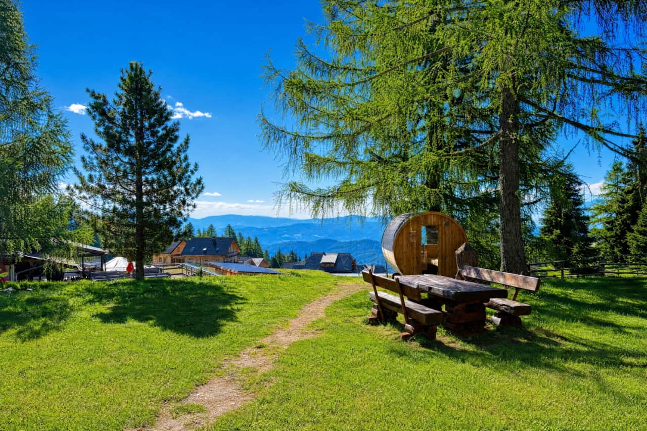 Gemütlicher Ruheplatz mit Panoramabank, Sauna im Hintergrund und freiem Bergblick
