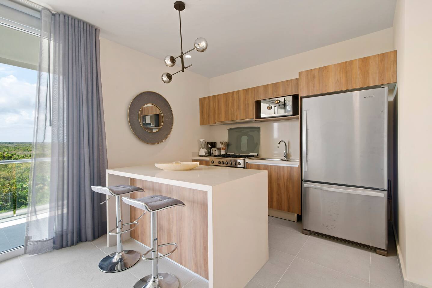 Fully equipped kitchen featuring two 5-gallon drinking water jugs, a dishwasher, microwave, coffee maker (with complimentary coffee), blender, toaster, full-size refrigerator, stove, and oven—everything you need to prepare and enjoy meals.