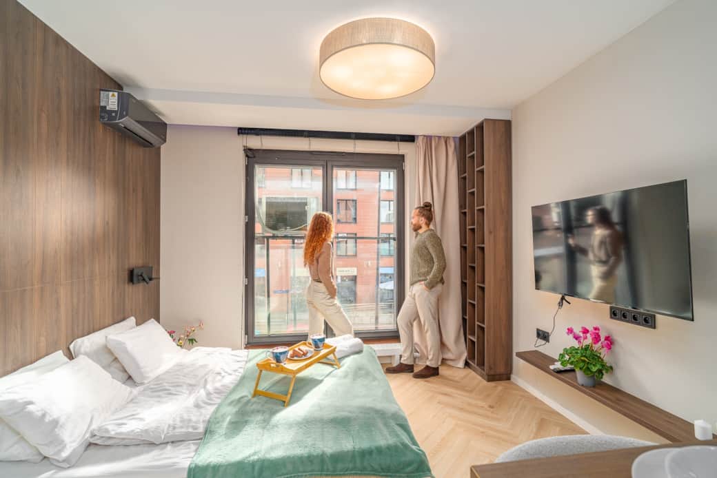 Bright bedroom area with a large bed and wide window for natural light.