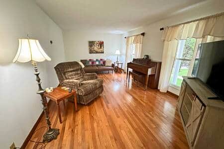 Living room with 55 inch Samsung smart tv, piano, and futon that converts to a bed.
