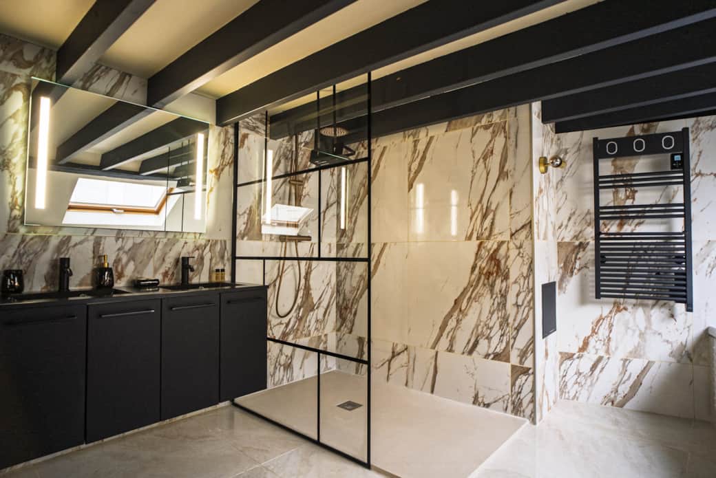 Marbre et lumière douce pour une salle de bain moderne et sophistiquée.