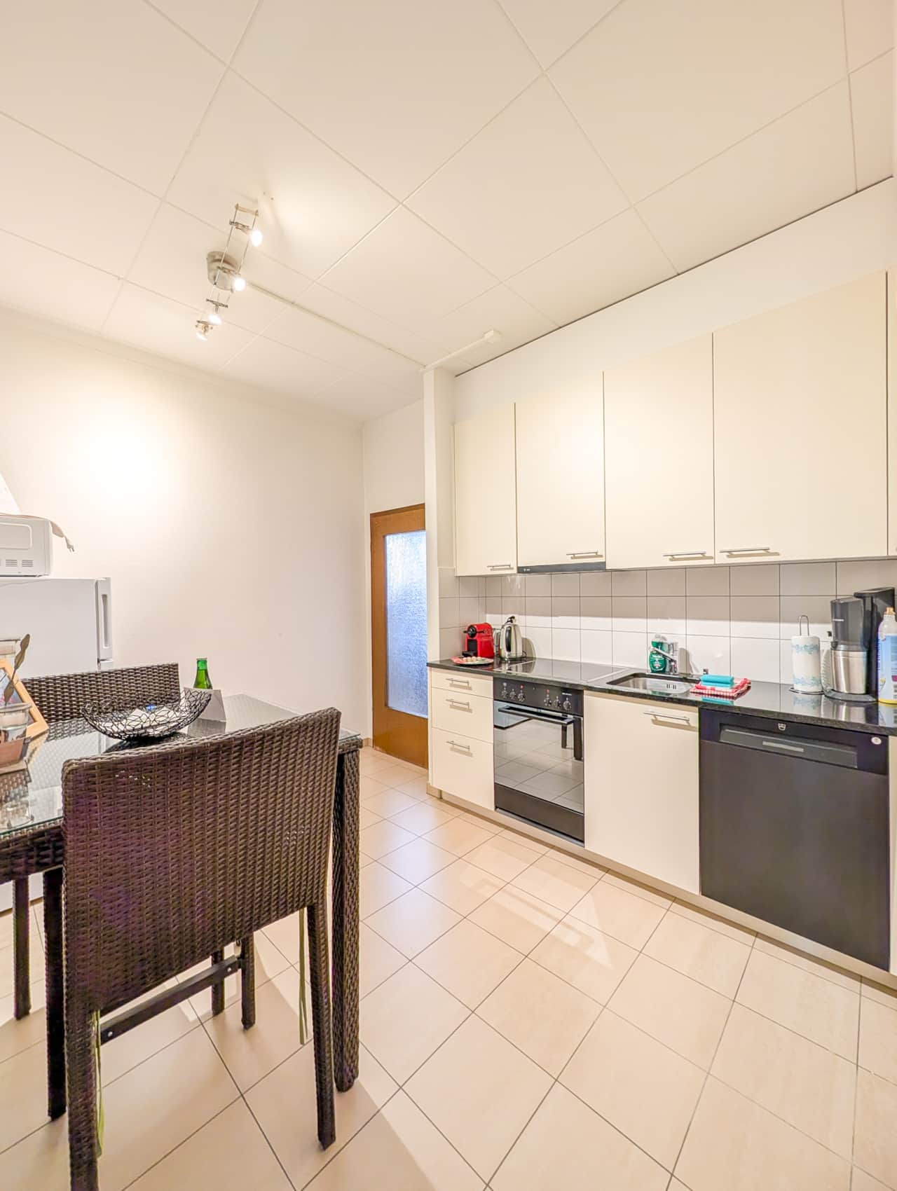 Fully equipped modern kitchen with small dining area.