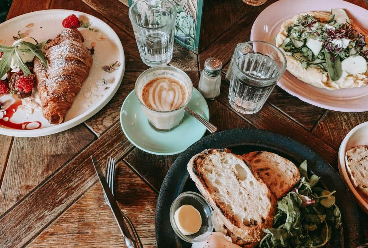 Breakfast table with croissant, eggs, and coffee