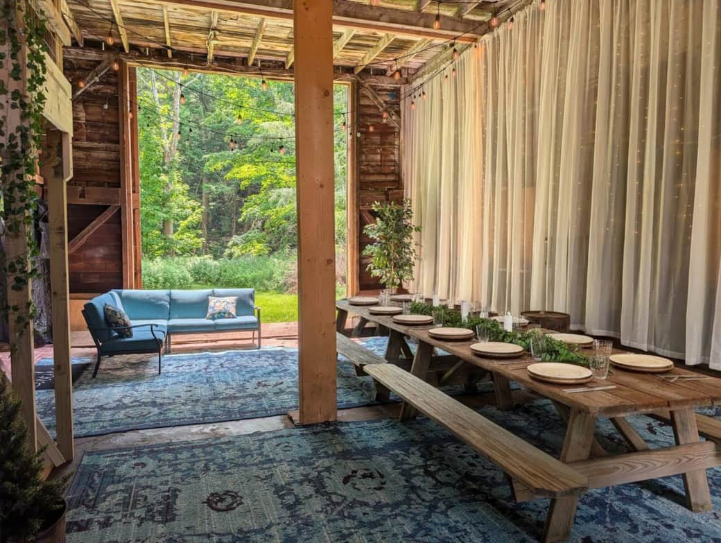 The barn door/wall slides open. The creek is just beyond the greenery in the background. (Table top setting generated by AI).