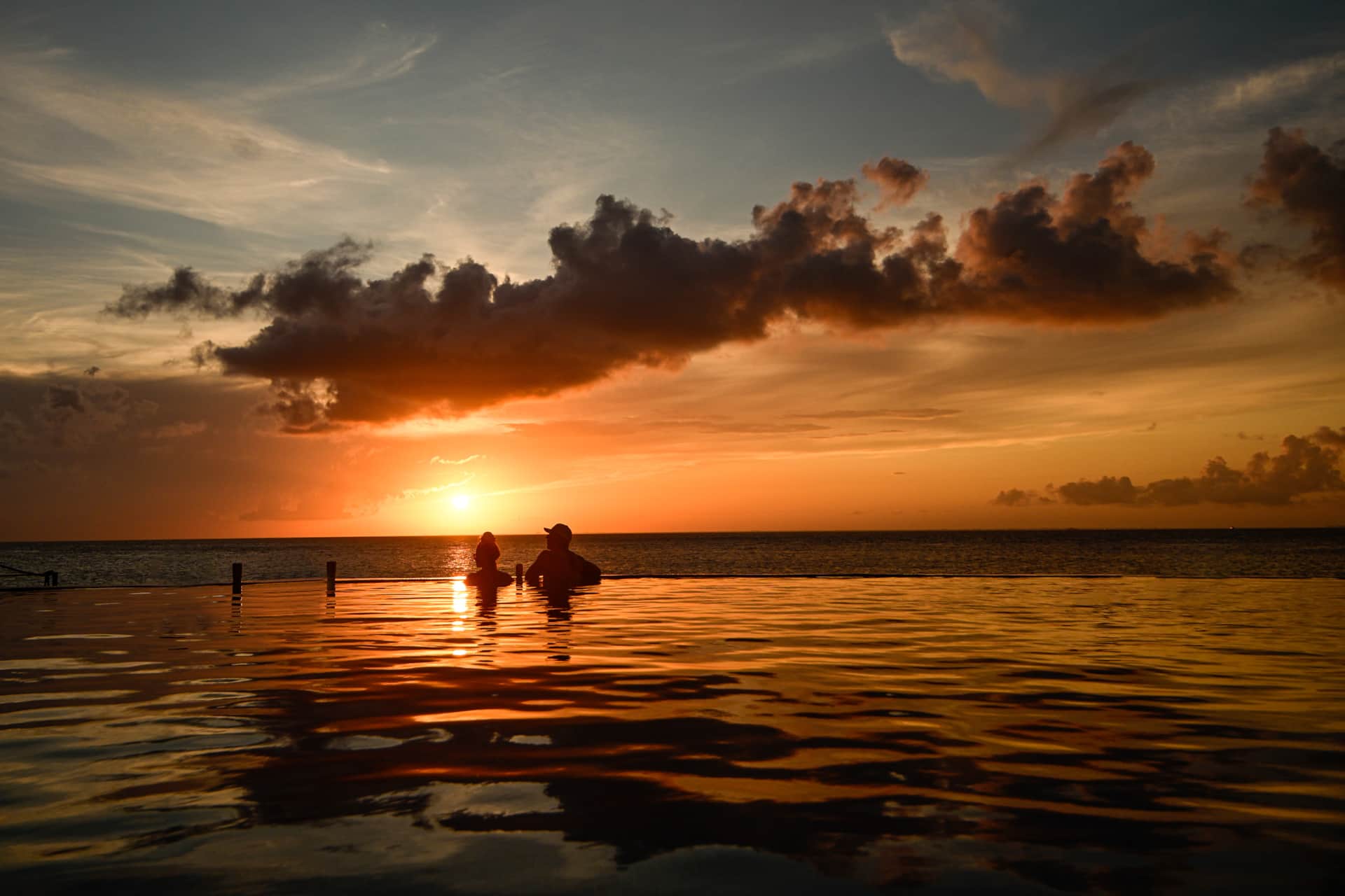 Guests enjoying sunset from the heated infinity pool overlooking the Caribbean Sea at Casa Graciela Cozumel