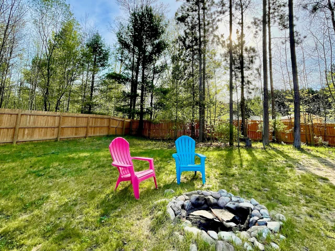 Fenced-in backyard includes fire pit.