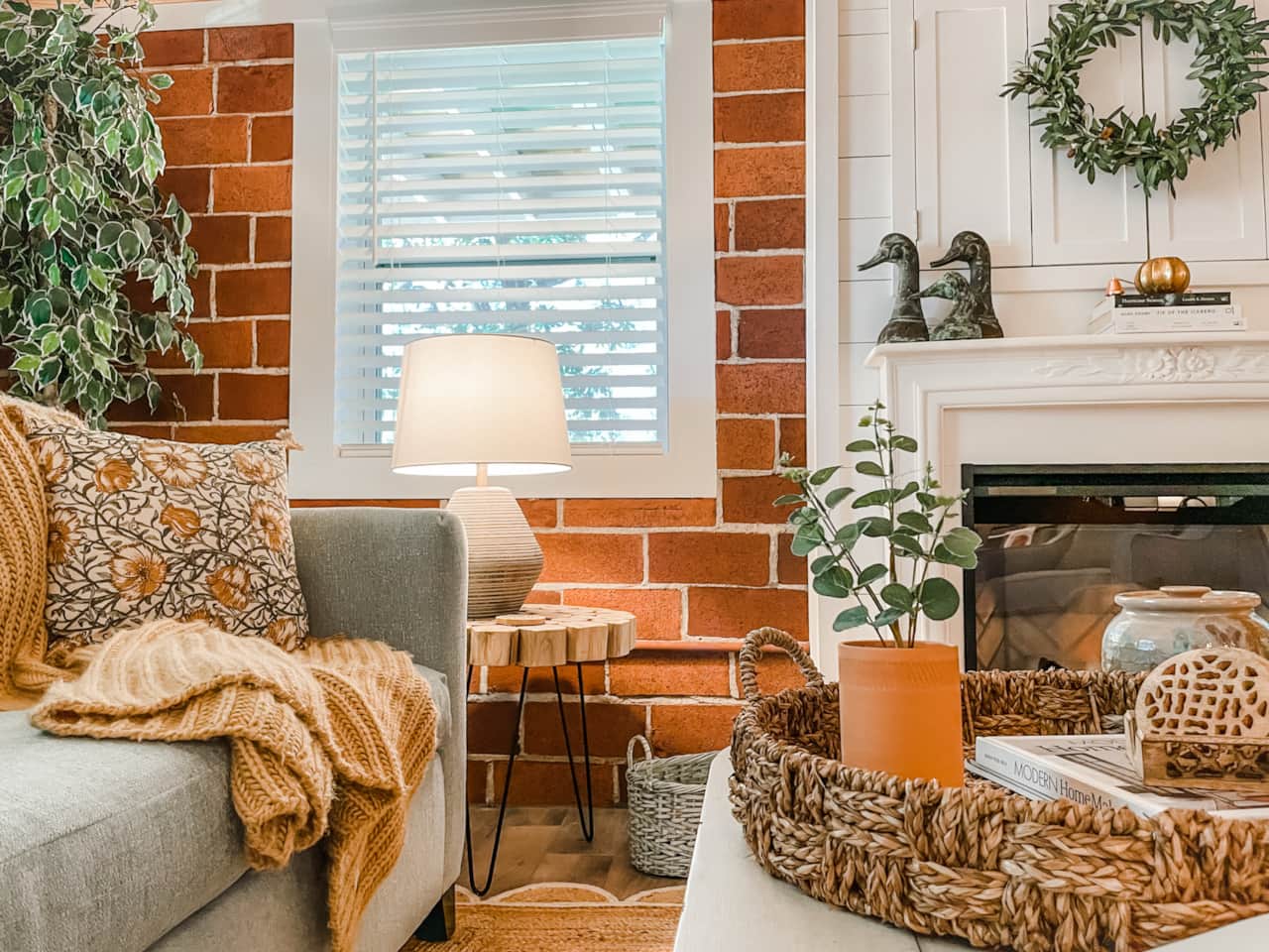 Original, exposed brick living room walls impart a rustic, coastal farmhouse feel.