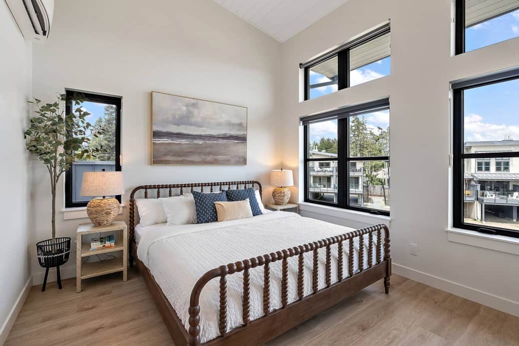 Ample primary bedroom with King sized bed, en suite bathroom, and oversized art