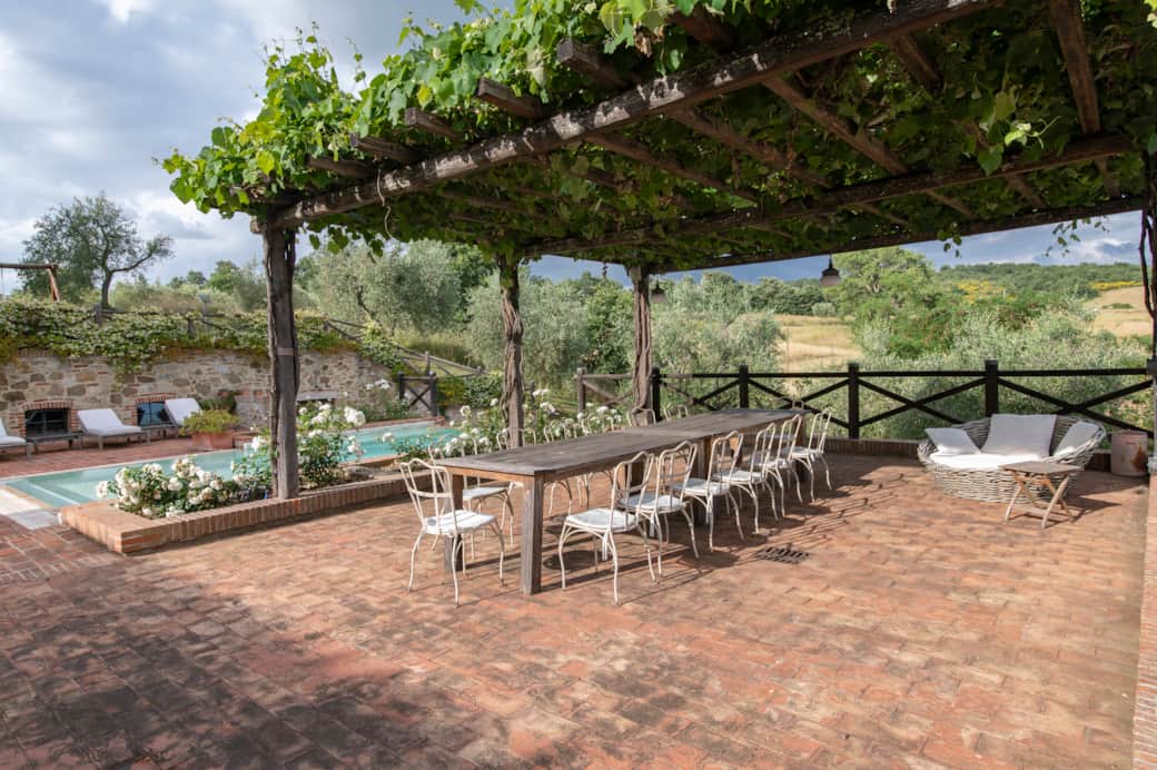 Shaded outdoor dining area under the pergola