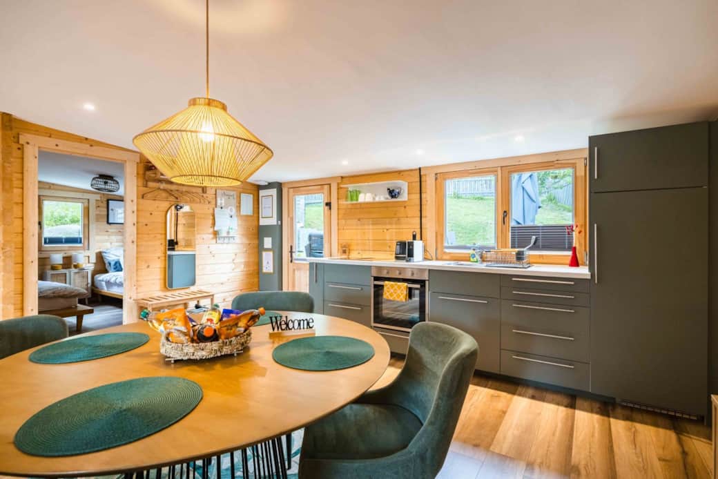 Bright Chalet Oz kitchen and dining space with modern appliances and wooden alpine interior Bright Chalet Oz kitchen and dining space with modern appliances and wooden alpine interior