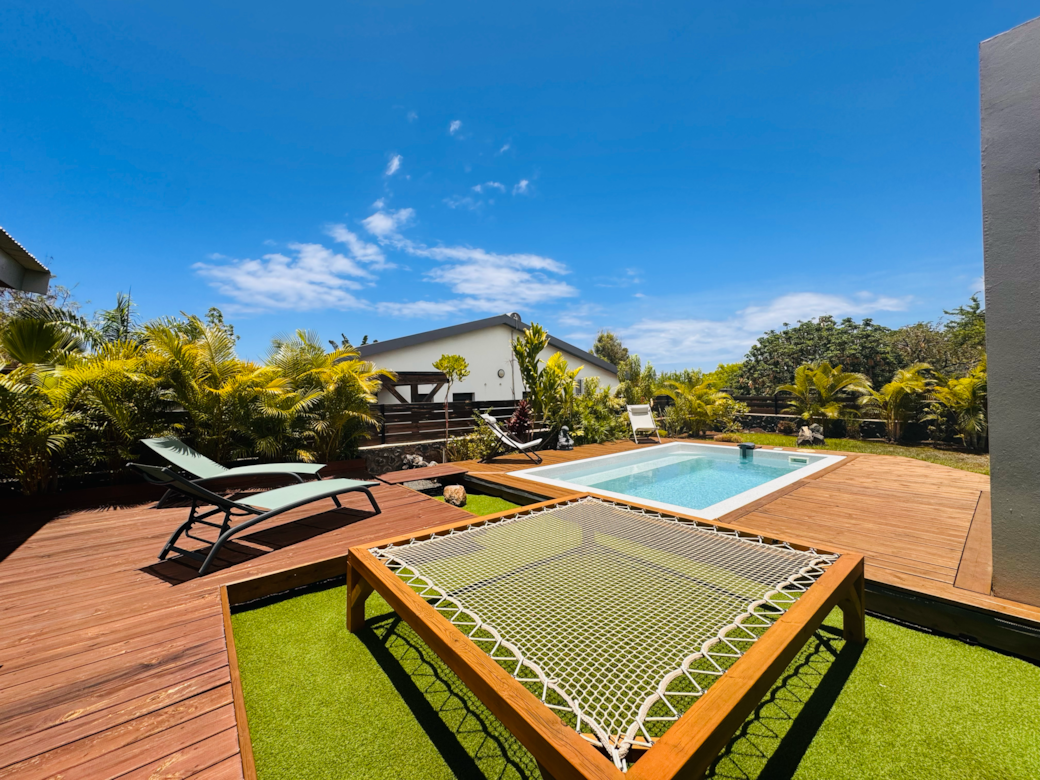 Espace détente avec piscine et filet suspendu, idéal pour des moments de relaxation uniques