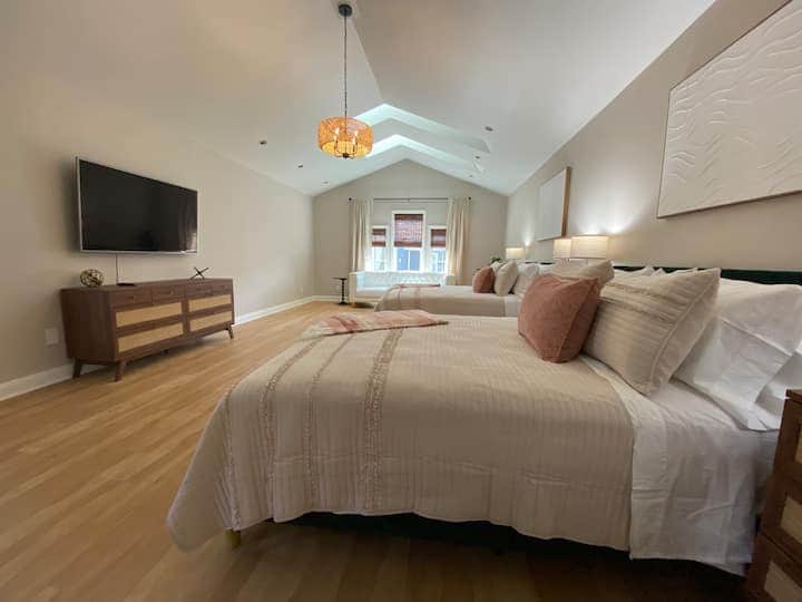Spacious and airy bedroom with vaulted ceilings and warm natural light.