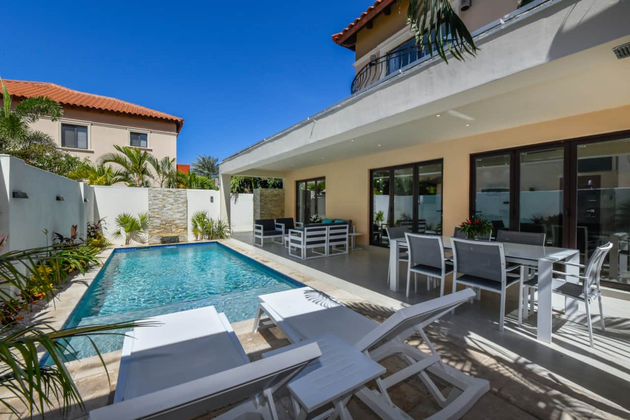 Private backyard with dining table, conversation set, and sun loungers