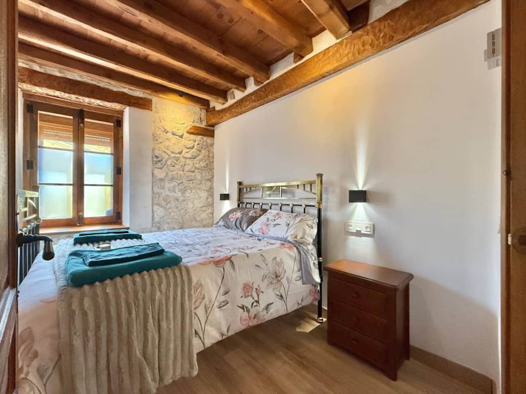 Dormitorio con cama de matrimonio antigua de toques en latón, que aporta elegancia y personalidad. Un espacio luminoso y acogedor con detalles rústicos para un descanso especial. Dormitorio con cama de matrimonio antigua de toques en latón, que aporta elegancia y personalidad. Un espacio luminoso y acogedor con detalles rústicos para un descanso especial.