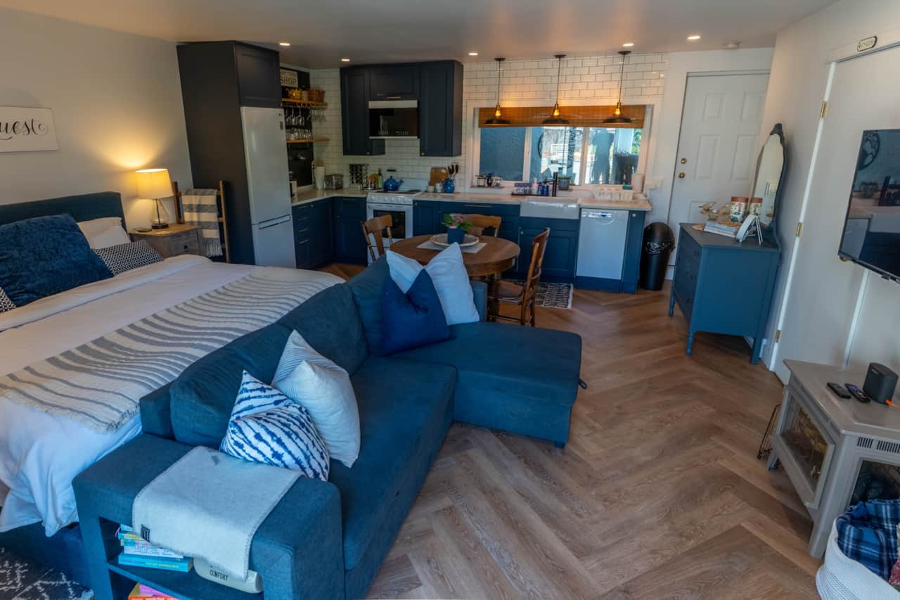 Studio space with king bed, sofa, TV, dining table, fully stocked kitchen, bathroom, and laundry.