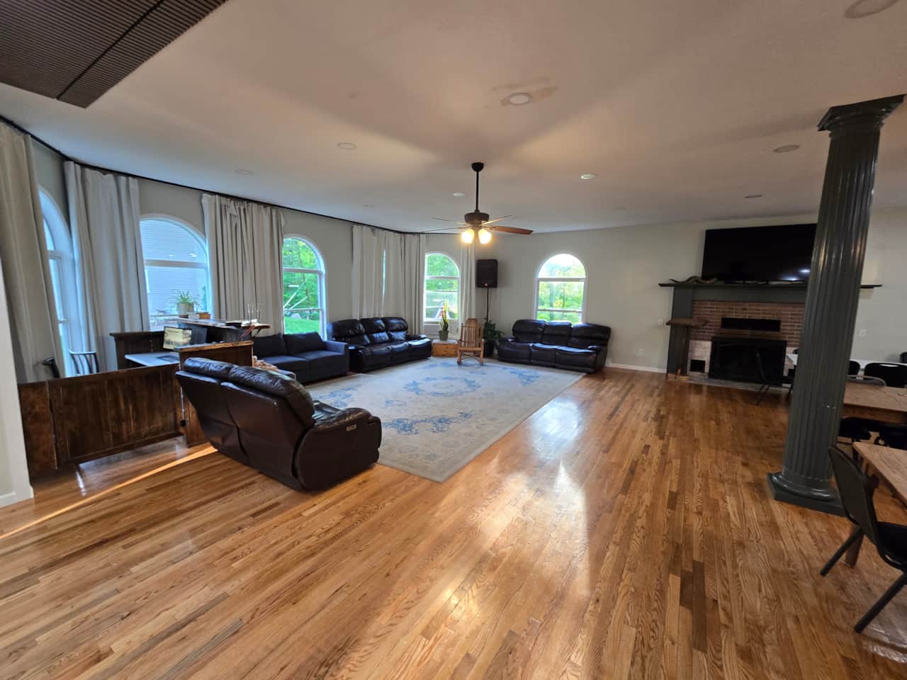 Living room with leather sofas, a fireplace, and large windows
