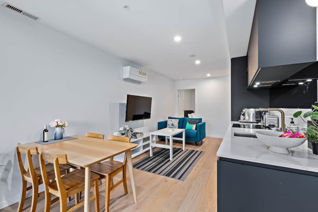 The open-plan design allows for easy interaction with the kitchen, making it perfect for entertaining. Enjoy your meals in a space that combines modern aesthetics with warm, inviting tones.