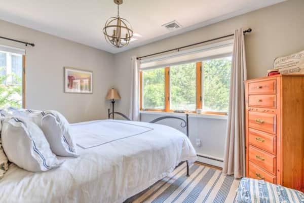 King bedroom upstairs with white bedding and a window to the trees