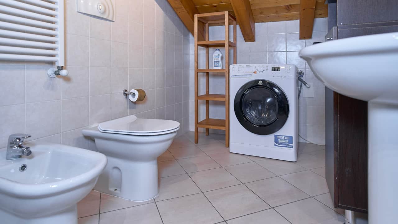 Bad mit Bidet, Waschbecken und Waschmaschine unter dem Dach