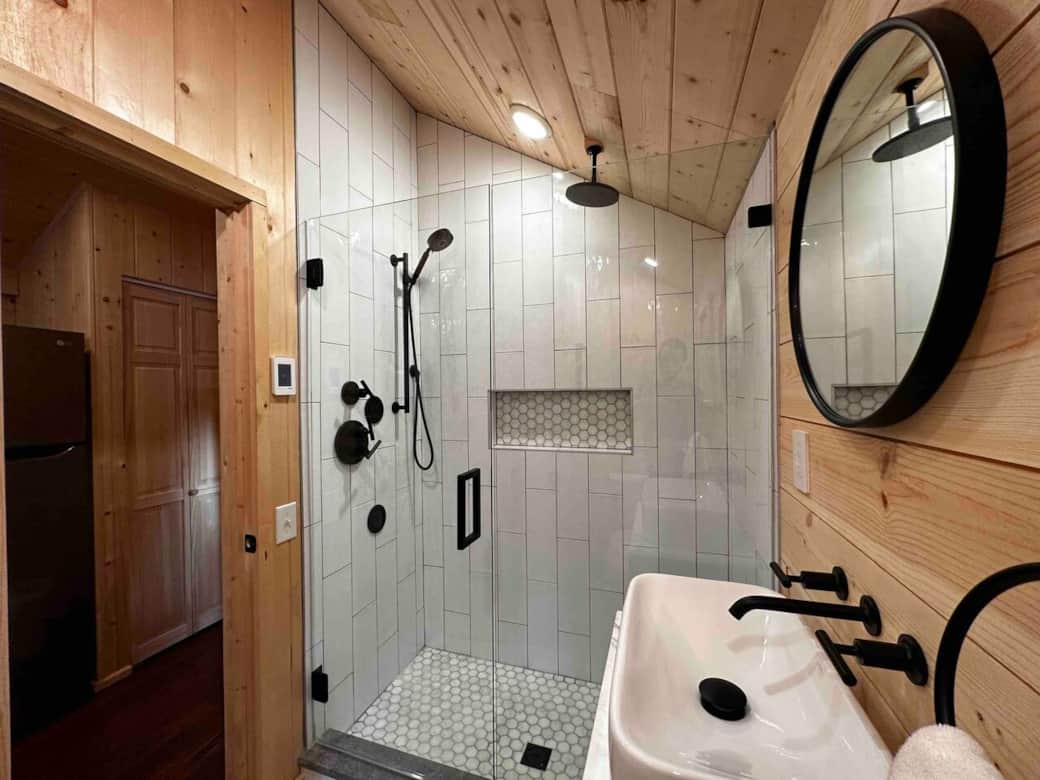 Spa-quality bathroom featuring a rainfall shower, body spray jets, and heated tile floors.