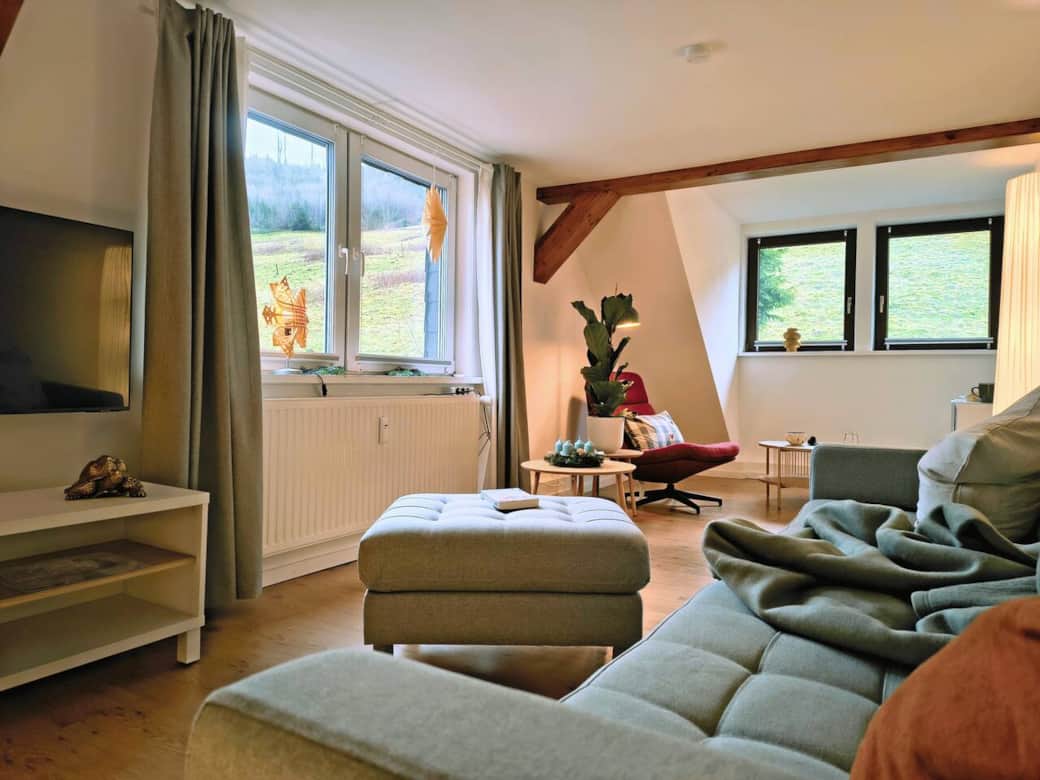 Helles, gemütliches Wohnzimmer mit großer Fensterfront ins Grüne, bequemer Couchlandschaft und kuscheliger Leseecke – perfekt zum Zurücklehnen nach einem Tag im Harz. Helles, gemütliches Wohnzimmer mit großer Fensterfront ins Grüne, bequemer Couchlandschaft und kuscheliger Leseecke – perfekt zum Zurücklehnen nach einem Tag im Harz.