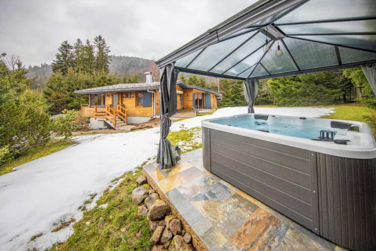 Superbe jacuzzi 6 places protégé par une terrasse couverte avec vue sur le chalet