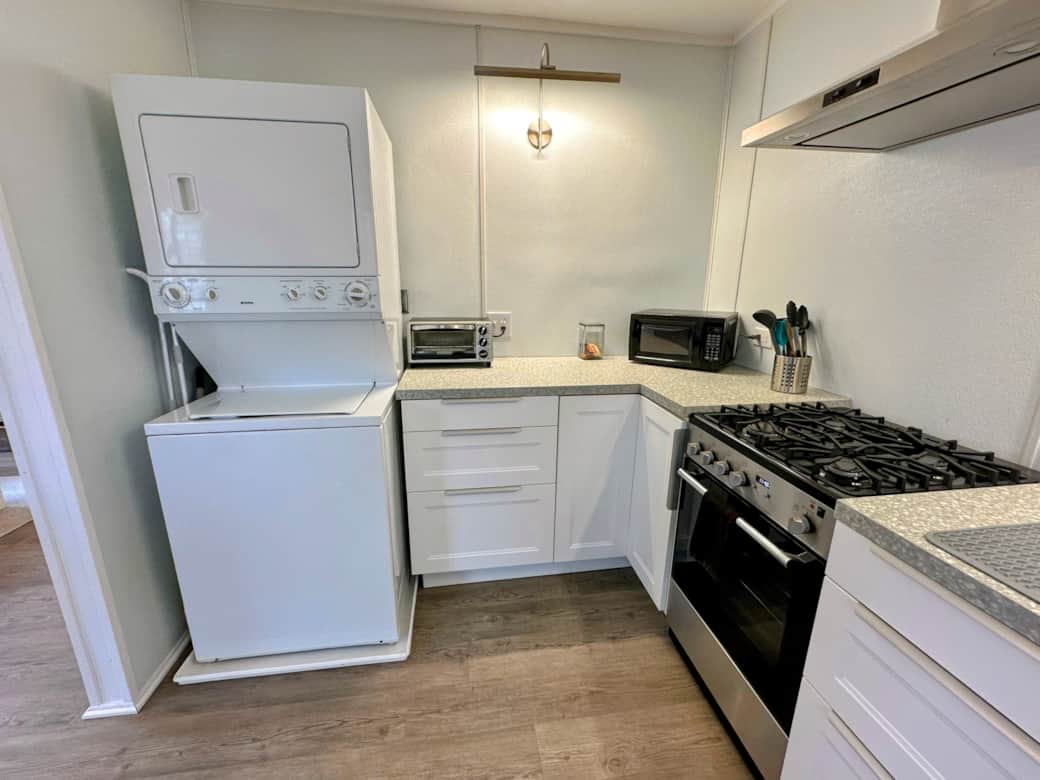 Laundry area with stacked washer/dryer. Kitchen includes a microwave, toaster oven, and coffeemaker. Laundry area with stacked washer/dryer. Kitchen includes a microwave, toaster oven, and coffeemaker.