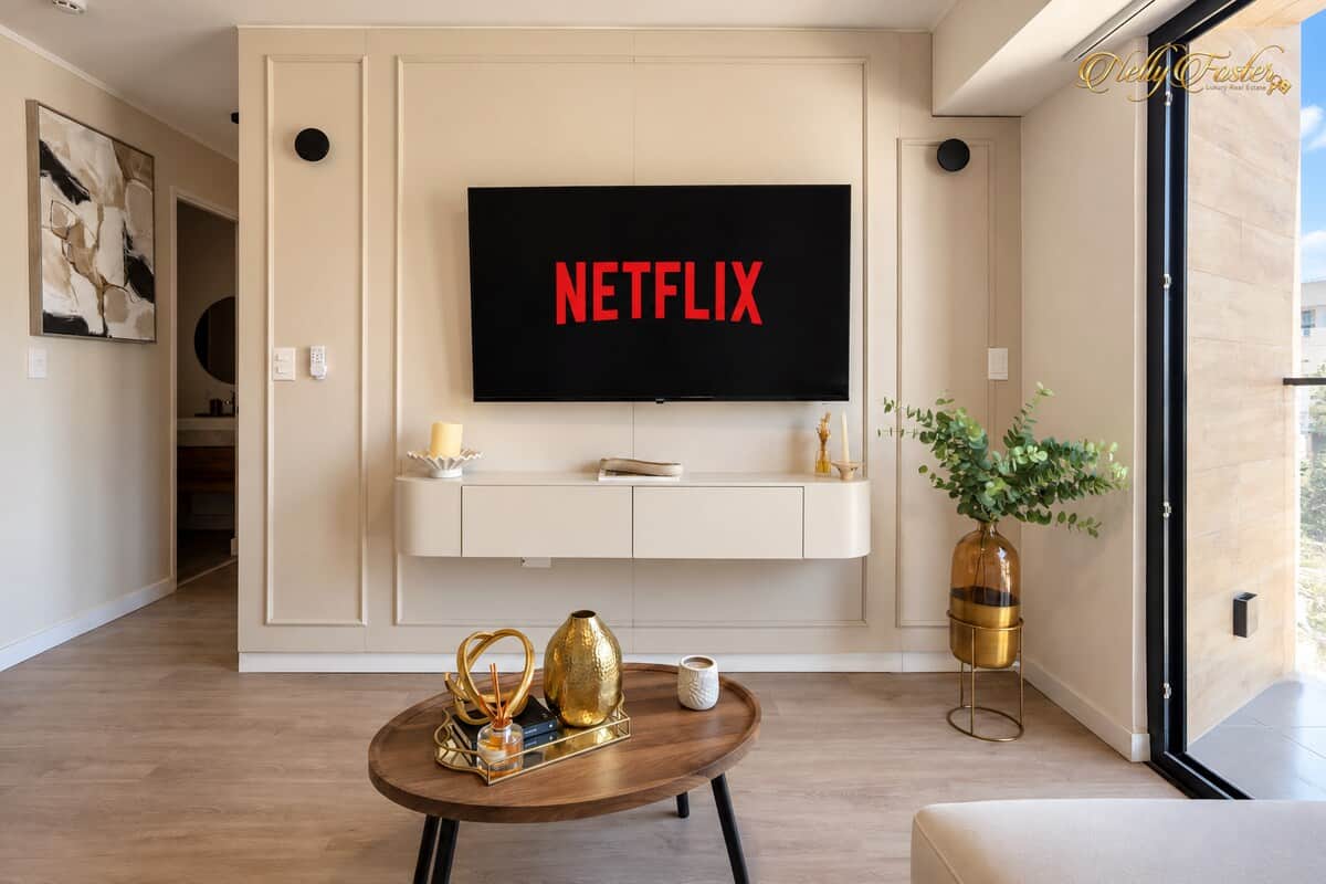Acogedora sala con Smart TV con Netflix, Disney+, y otras aplicaciones, iluminación cálida y acceso al balcón.