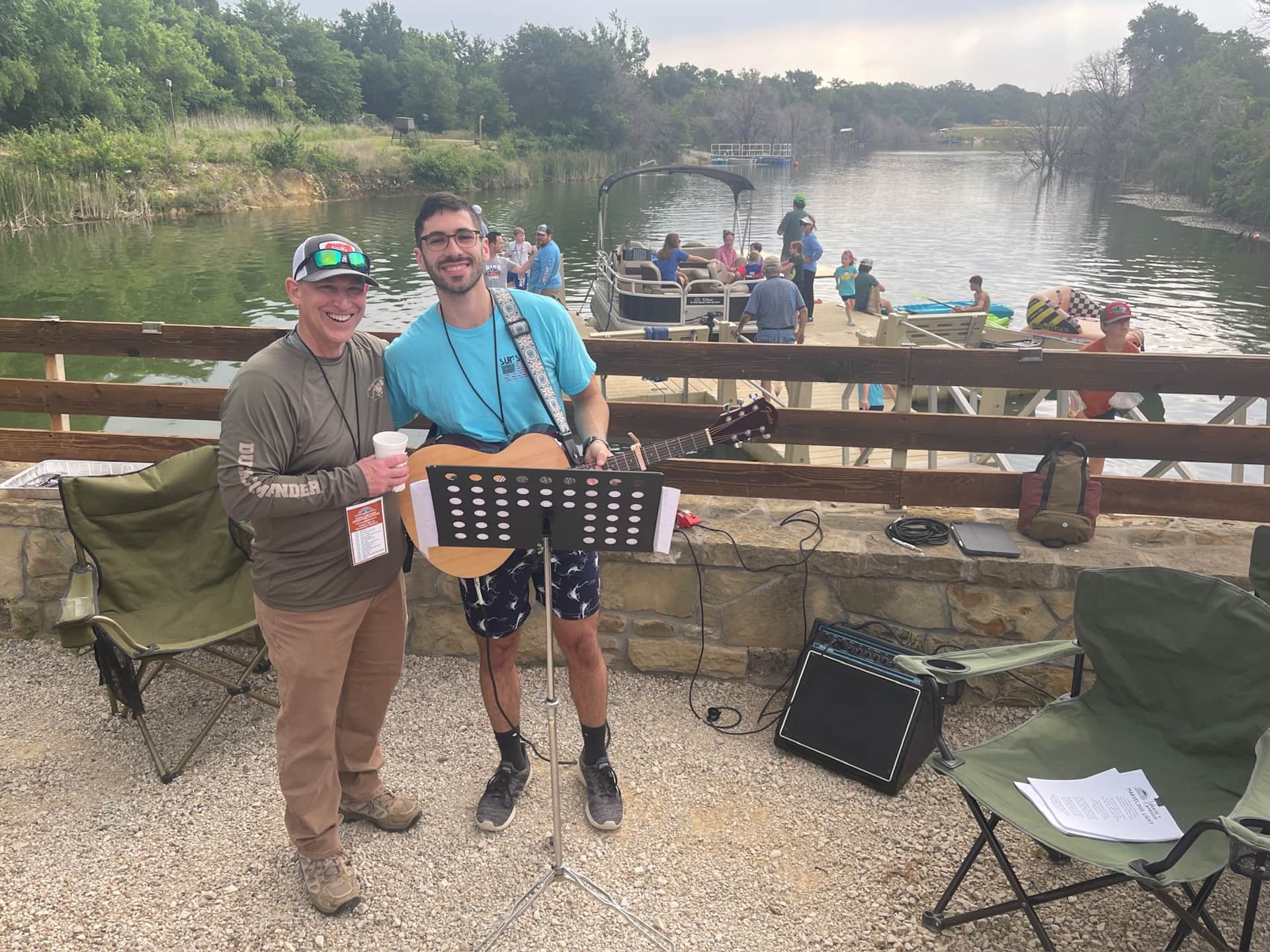 Church family camp musicians preparing for worship at the lodge fire pit overlooking Lake Godstone Graford TX
