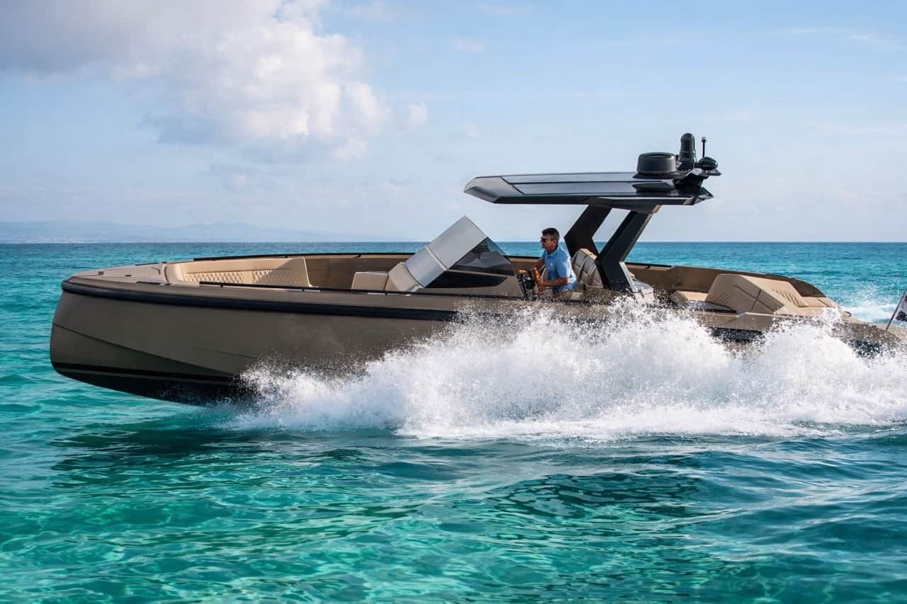 Vanquish VQ40 captain at the helm in turquoise shallow waters near Costa Smeralda — luxury day charter from Olbia with dramatic bow spray