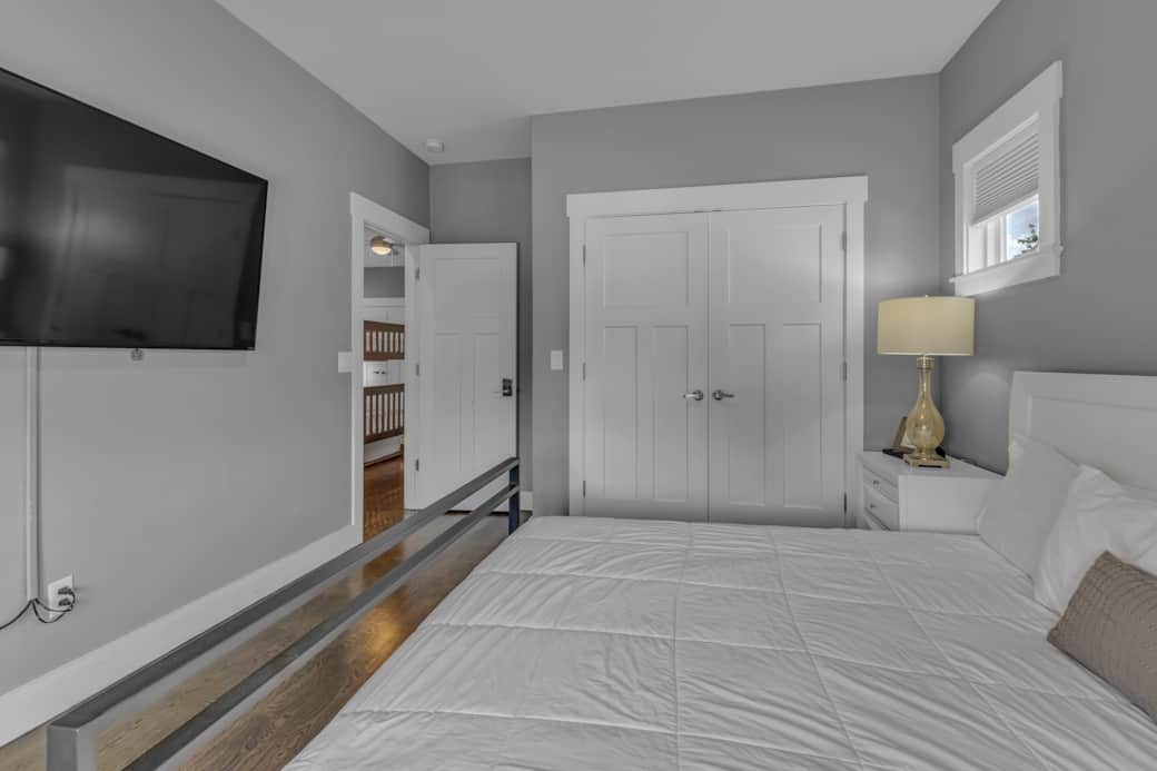 Upstairs bedroom with king bed and large flatscreen TV.