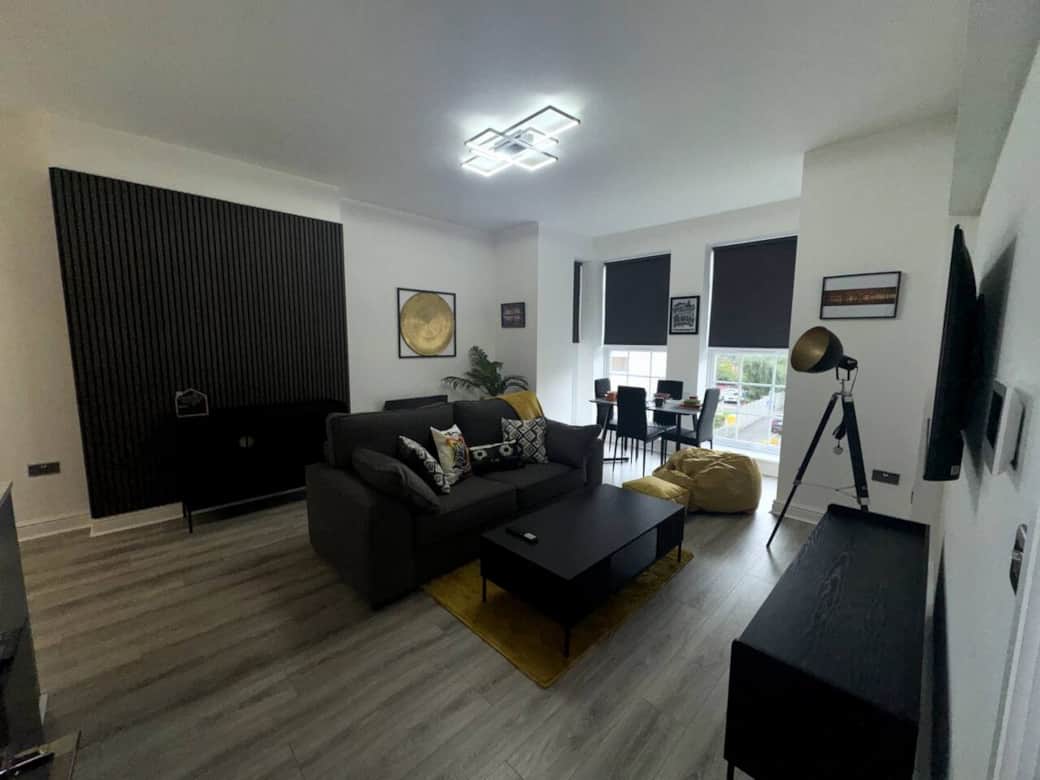 modern stylish living area with double sofa bed and smart tv, dining area